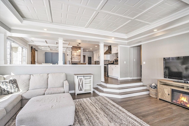 living room with dark hardwood / wood-style flooring, crown molding, and ornate columns