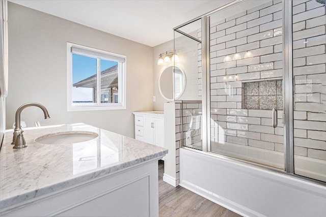 bathroom featuring vanity, hardwood / wood-style floors, and bath / shower combo with glass door