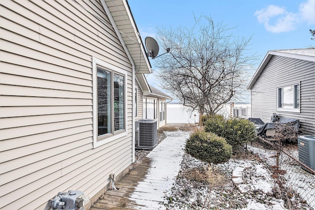 view of snow covered exterior featuring cooling unit and a deck