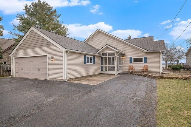 view of front of house featuring a garage and a sunroom