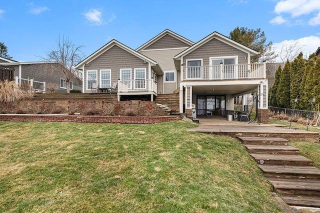 rear view of house with a wooden deck and a yard