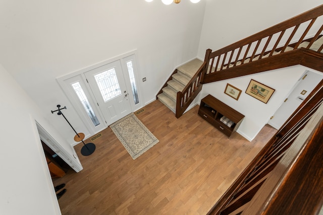 entryway with a towering ceiling and light wood-type flooring