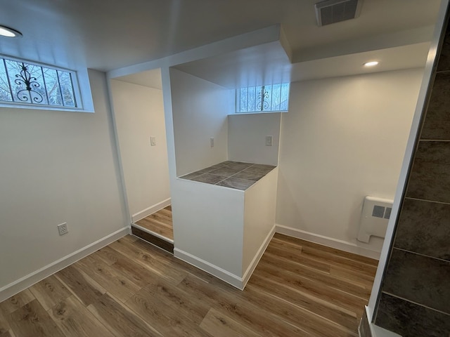 laundry area featuring hardwood / wood-style flooring and radiator