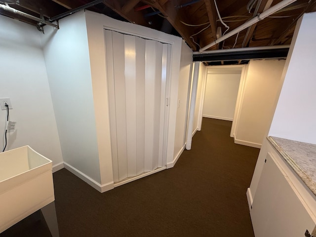 basement with sink and dark carpet