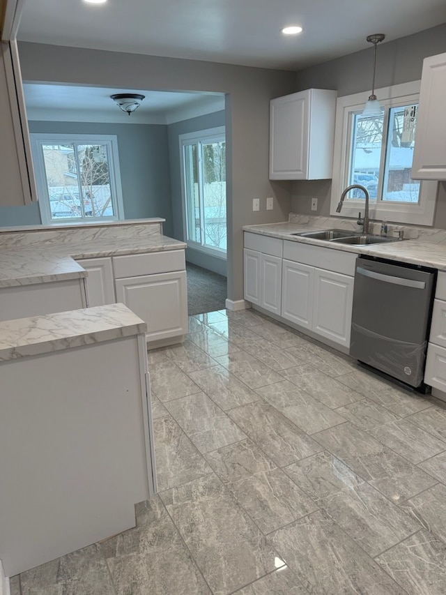 kitchen featuring dishwasher, sink, pendant lighting, and white cabinets