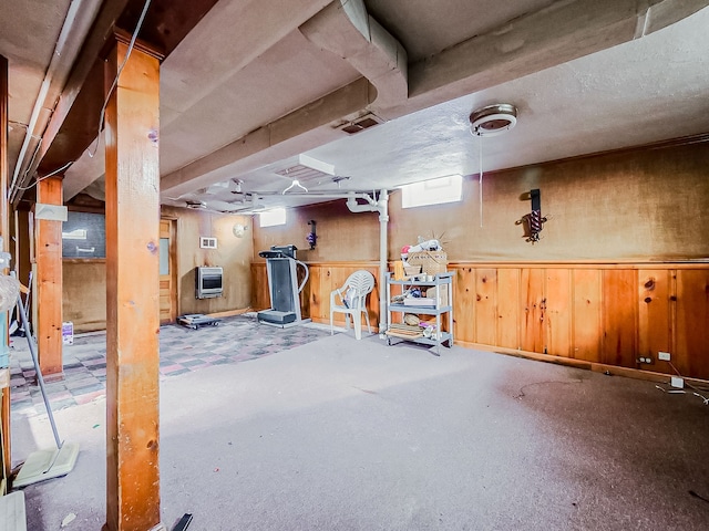 basement featuring heating unit and wooden walls