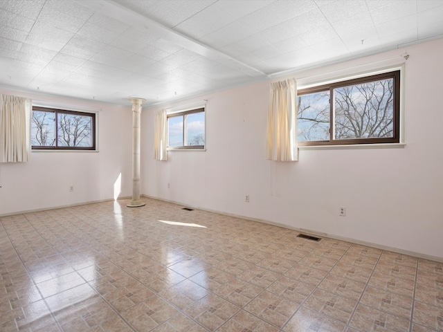 1397 N Channel Dr, Harsens Island, MI 48028 - unfurnished room with healthy amount of natural light, baseboards, and decorative columns