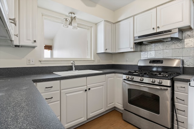 kitchen with sink, white cabinets, decorative backsplash, a notable chandelier, and stainless steel gas range oven