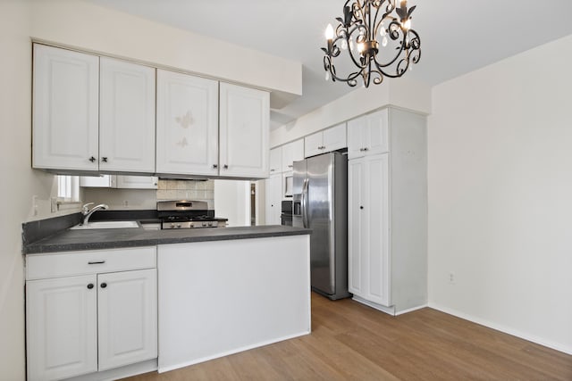 kitchen with white cabinetry, appliances with stainless steel finishes, sink, and decorative light fixtures