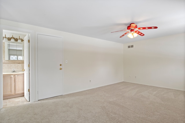 empty room featuring ceiling fan and light carpet