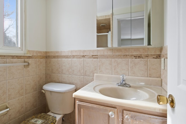 bathroom featuring vanity, tile walls, and toilet