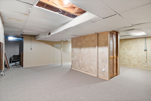 basement featuring carpet and a drop ceiling