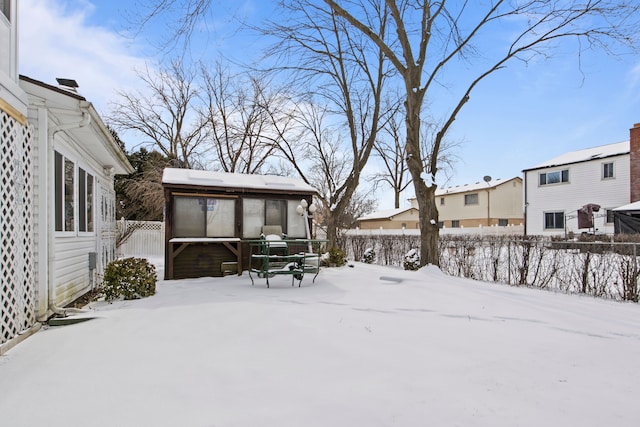 yard covered in snow featuring a sunroom