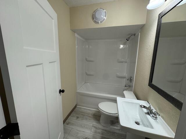 full bathroom with tub / shower combination, sink, and toilet