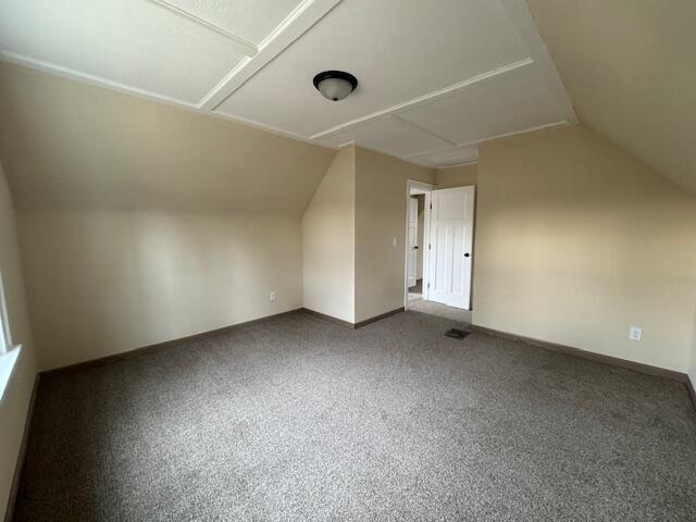 additional living space featuring lofted ceiling