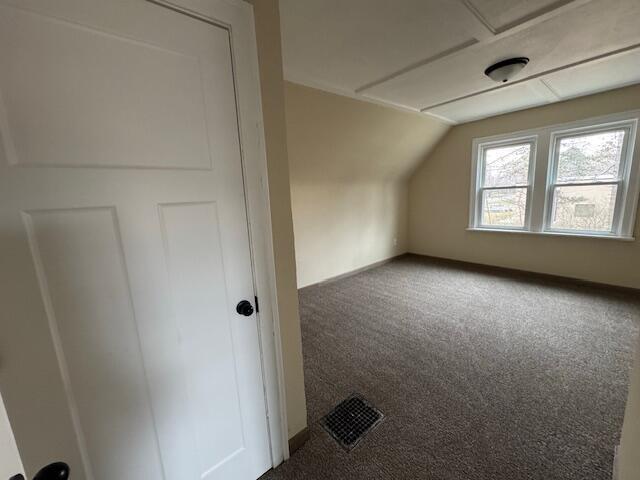 additional living space featuring lofted ceiling and carpet floors