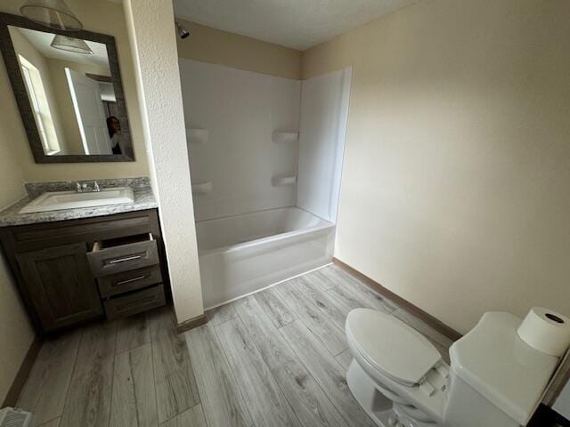 full bathroom featuring vanity, toilet, bathing tub / shower combination, and hardwood / wood-style floors