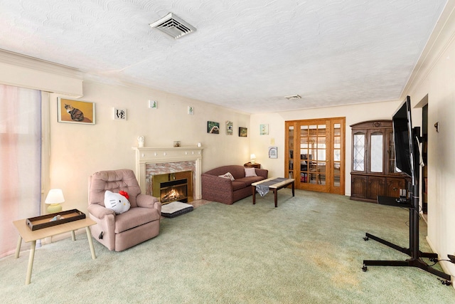 carpeted living room featuring crown molding, a fireplace, french doors, and a textured ceiling