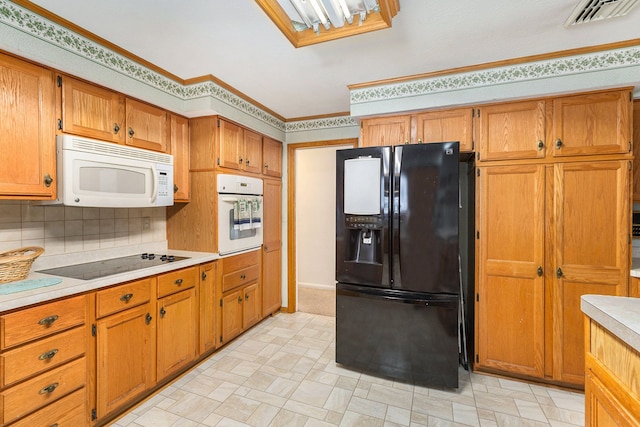 kitchen with crown molding, backsplash, and black appliances