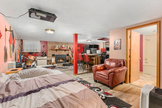 bedroom with a fireplace and light hardwood / wood-style flooring