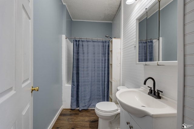 full bathroom featuring hardwood / wood-style floors, vanity, shower / tub combo, toilet, and a textured ceiling