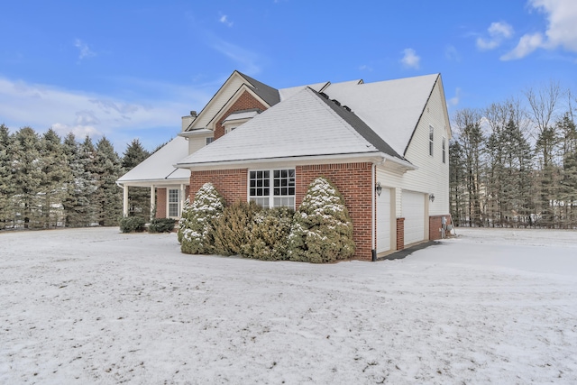 snow covered property featuring a garage