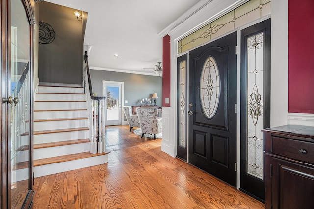 entrance foyer with crown molding and light hardwood / wood-style floors