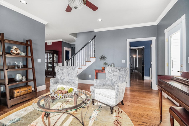 living room featuring wood-type flooring, plenty of natural light, ceiling fan, and crown molding