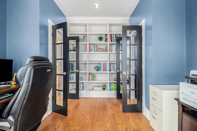 home office with light hardwood / wood-style floors and built in shelves