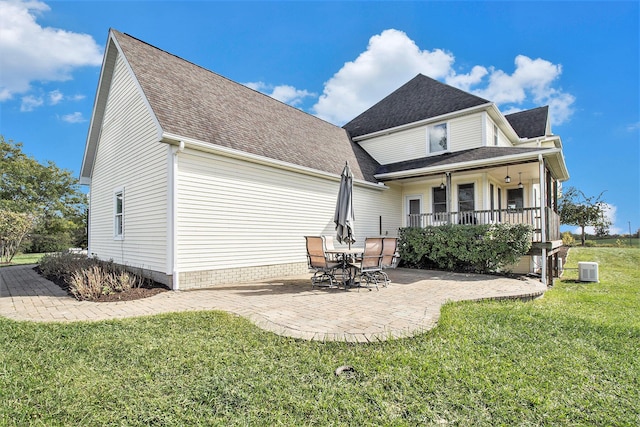 back of house with a yard, covered porch, and a patio area