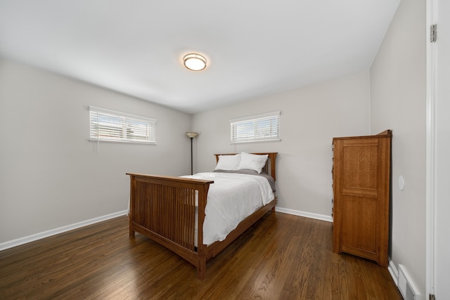 bedroom featuring multiple windows and dark hardwood / wood-style flooring