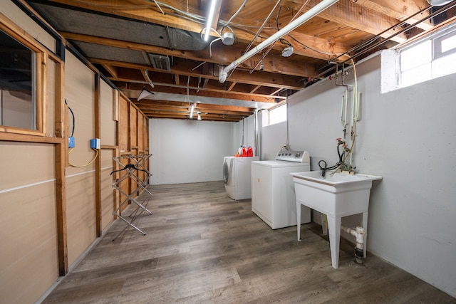 laundry area with hardwood / wood-style flooring, a healthy amount of sunlight, and washer and clothes dryer