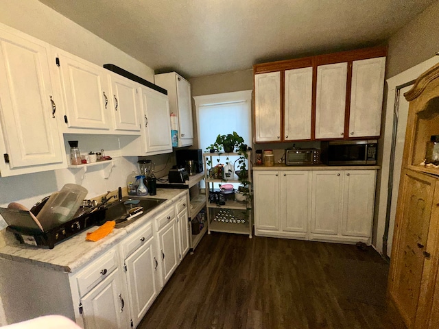 kitchen with dark hardwood / wood-style floors, sink, and white cabinets