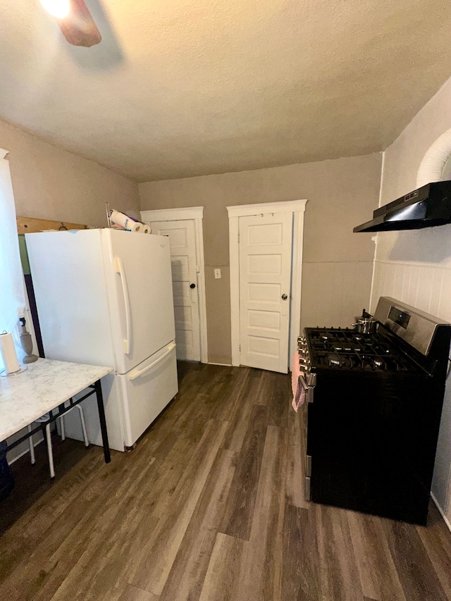 kitchen with gas range, dark wood-type flooring, white fridge, and a textured ceiling