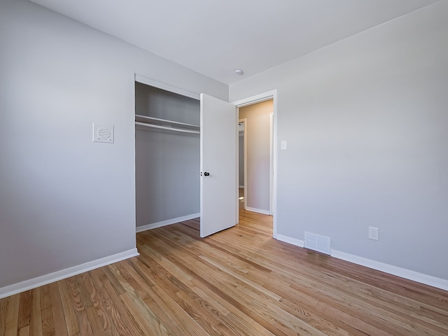 unfurnished bedroom with a closet and light hardwood / wood-style flooring