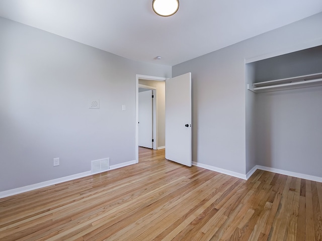 unfurnished bedroom with light hardwood / wood-style floors and a closet