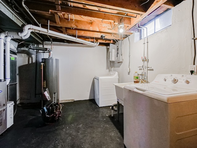 basement featuring water heater, electric panel, and washer and clothes dryer