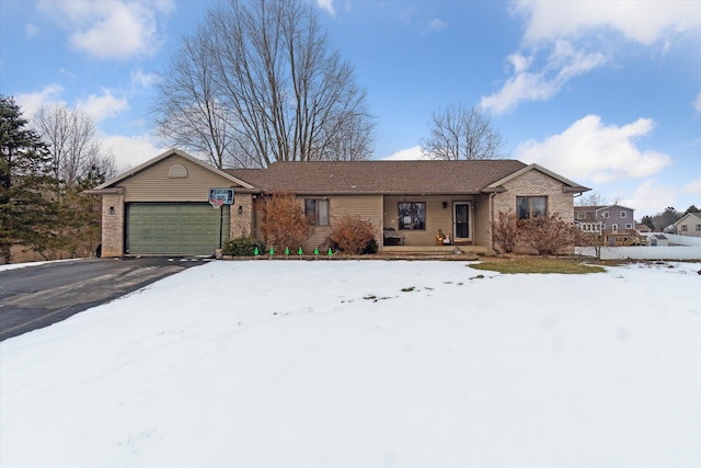 ranch-style house with an attached garage, aphalt driveway, and brick siding