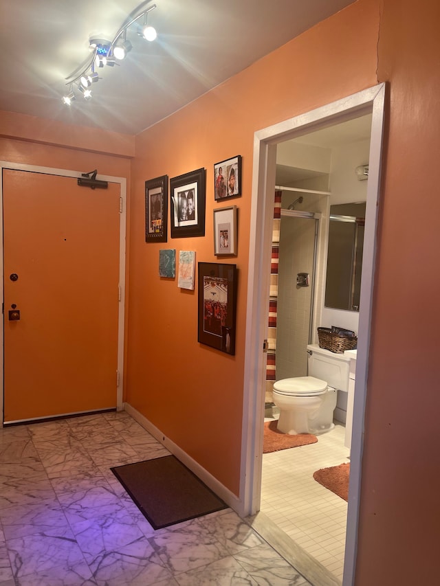 hallway featuring baseboards and marble finish floor