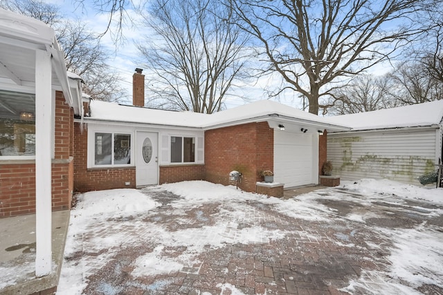 snow covered property featuring a garage