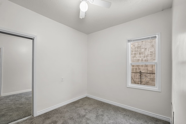 unfurnished bedroom with multiple windows, a textured ceiling, and carpet flooring