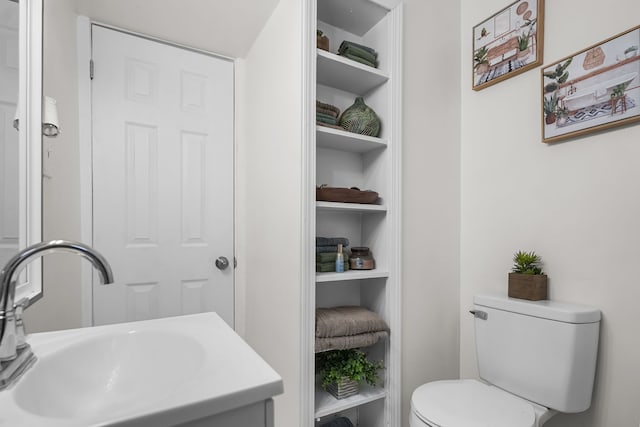 bathroom featuring sink, built in features, and toilet