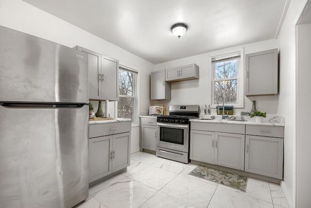 kitchen with sink, gray cabinets, plenty of natural light, and appliances with stainless steel finishes