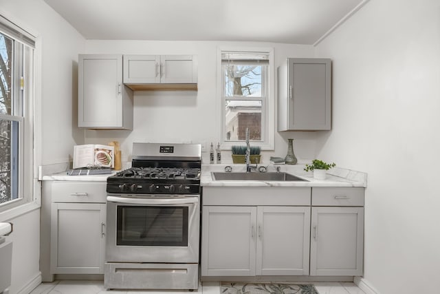 kitchen featuring sink, gray cabinets, and gas stove