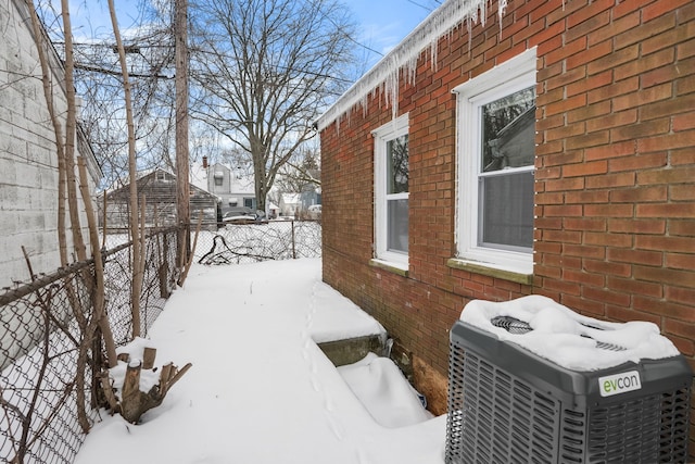 view of snow covered exterior with central AC