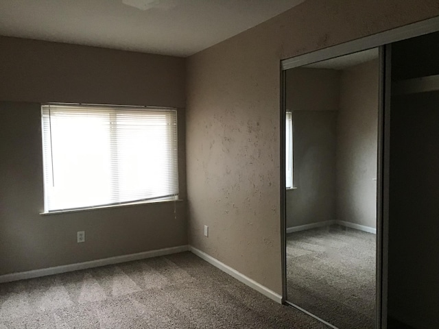 unfurnished bedroom with a closet and carpet flooring