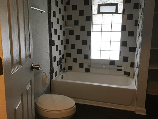 bathroom with tiled shower / bath and toilet