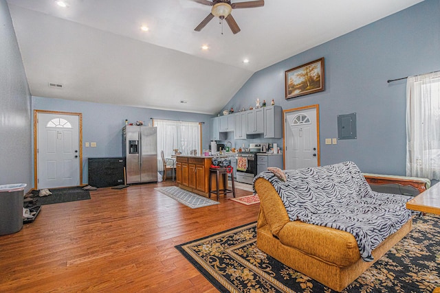 living room featuring vaulted ceiling, light hardwood / wood-style floors, and ceiling fan