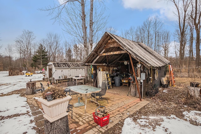 snow covered patio with a storage unit