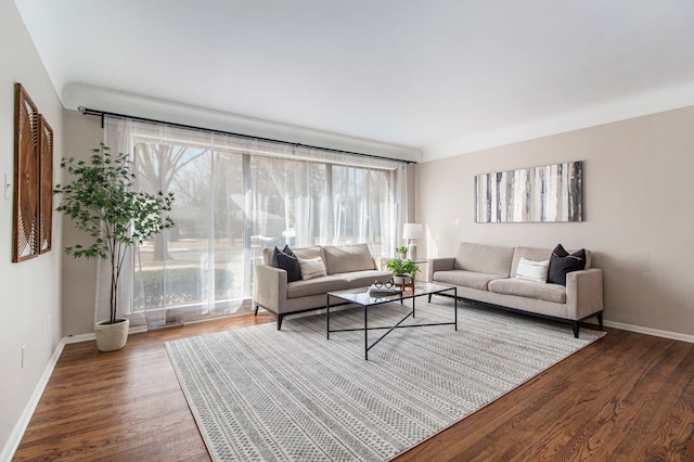 living area with baseboards and wood finished floors